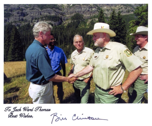 President Bill Clinton shakes hands with Chief Thomas. In the background, from left to right, are Brian Burke, Deputy Undersecretary of Agriculture, Richard Bacon, Deputy Regional Forester of Region 1, and Dave Garber, forest supervisor of the Gallatin National Forest. The photo was taken in August 1996 in Yellowstone National Park.